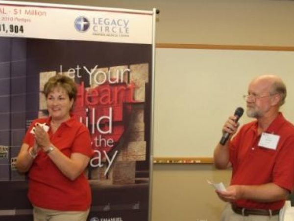 Susan Quigley, community fund drive divisional leader, and Bill Gibbs, community fund drive chair, announce Thursday night’s results at Legacy Circle of Emanuel’s weekly report session.