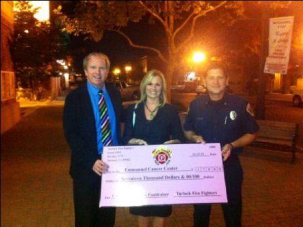 Turlock firefighters presented a big pink check in the amount of $17,000 to Emanuel Medical Center representatives after a month-long pink t-shirt fundraiser. 11-13-12